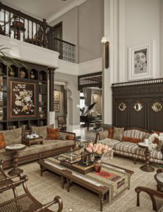 Phòng khách phong cách Indochine với tông màu trầm ấm, nội thất gỗ tự nhiên và ánh sáng vàng dịu tạo cảm giác ấm cúng, thanh lịch